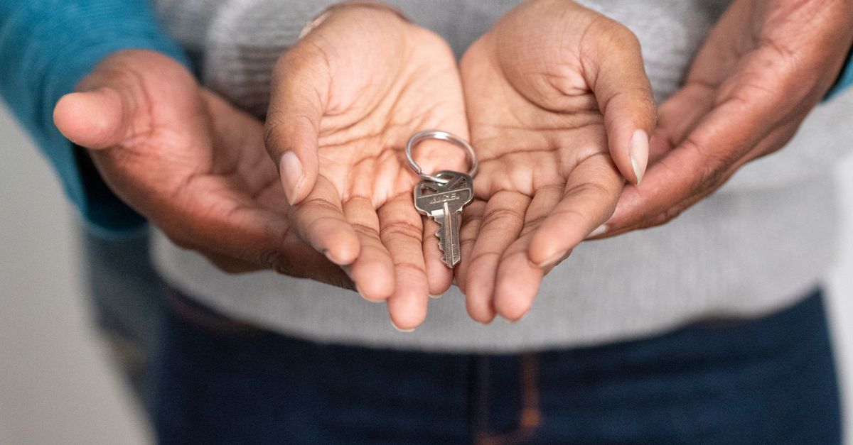 Close-up of hands holding a key, representing new homeownership and property investment.